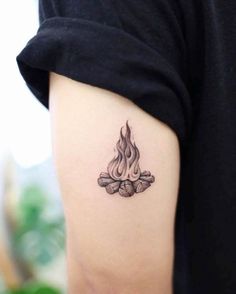 a woman's arm with a tattoo on it that has a fire in the middle