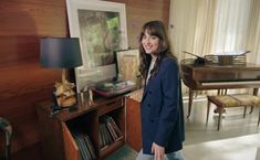 a woman is standing in front of a piano and other musical instruments on the table