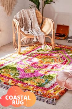 a colorful rug in the corner of a room with a chair and potted plant