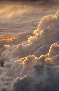 an airplane is flying high above the clouds