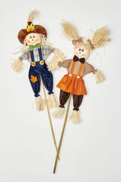 two scarecrows made out of wood sticks on a white background