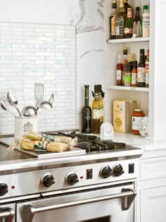 a stove top oven sitting inside of a kitchen next to a wall mounted spice rack