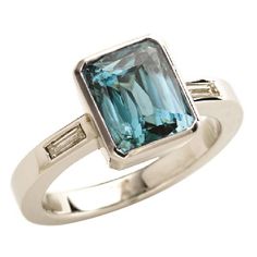 a ring with an aqua blue topazte and baguettes on the sides