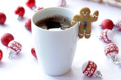 a cup filled with hot chocolate and a gingerbread man sticking out of the top