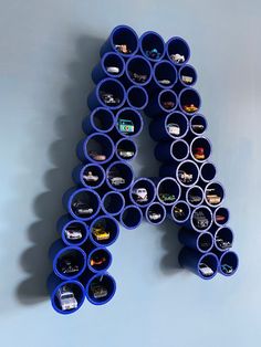 the letter k is made out of blue plastic tubes and has cars on them in it