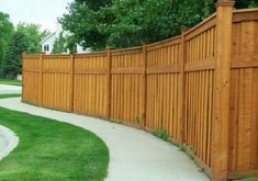 a long wooden fence next to a sidewalk