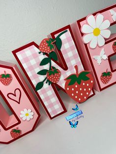 the letters are made out of paper and have strawberries on them