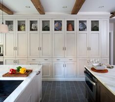 a large kitchen with white cabinets and counter tops