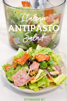 a salad on a plate next to a glass bowl