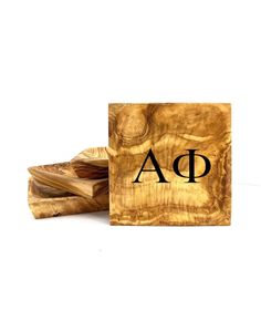 wooden coasters with the letter a and d in black ink on top of each other