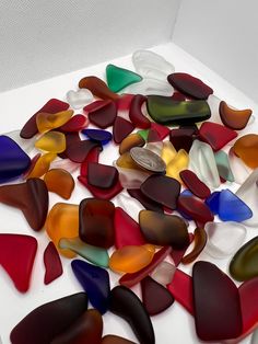 a pile of colorful glass pieces sitting on top of a white table