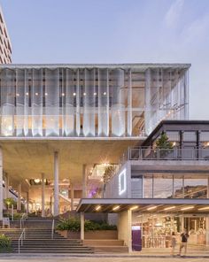 a large building with stairs leading up to it and people walking around the outside area