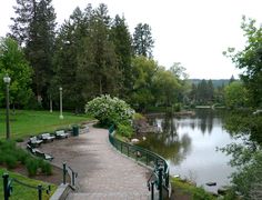 a walkway that is next to a body of water with benches on the other side