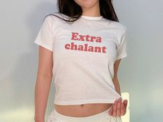 'Extrachalant' Baby Tee The model in the main image is 5'1 and is wearing an XS.  She is 105lb, chest 33C - typically wears an XS - Trendy Y2K Baby tee style for adults - This is a 90s style Baby tee which runs true to size (please see size chart) - 100% cotton (180 g/m²) Our main production is in California, US but we ship from distribution hubs located around the world including Canada, Europe, UK & Australia to reduce shipping time.  If your country isn't currently listed, please reach out an White Stretch Y2k T-shirt, White Y2k Style Stretch T-shirt, Y2k T-shirt With Custom Print In Relaxed Fit, Funny Text Stretch Short Sleeve T-shirt, Unisex Y2k Style Short Sleeve T-shirt, Y2k Style Unisex Short Sleeve T-shirt, Y2k White T-shirt With Funny Text, White Y2k T-shirt With Funny Text, Baby Tees 90s