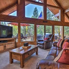 a living room filled with furniture and a flat screen tv on top of a wooden table