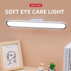 the soft eye care light is on top of a desk next to two books and a cactus