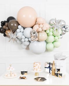 a table topped with balloons and cake next to a wall mounted star wars balloon sculpture