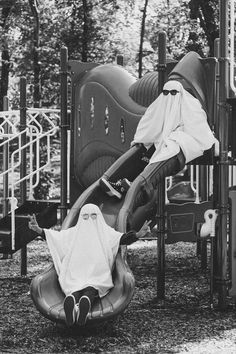 a black and white photo of a child's play area at a park with slides