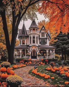 a large house with lots of pumpkins in the front yard and trees around it