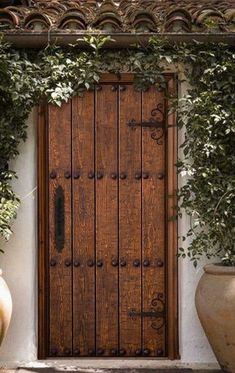 a large wooden door sitting between two planters