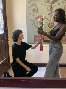 two women in a room one holding a candle and the other kneeling down