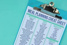 a clipboard with a meal planning sheet attached to it on a blue tablecloth