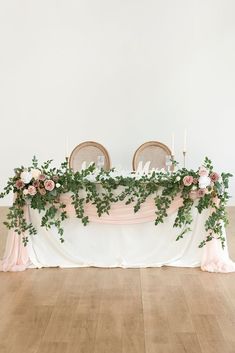 the table is covered with greenery and candles for an elegant touch to the space