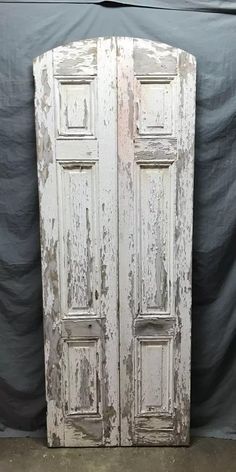 an old white double door with peeling paint