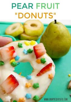 a close up of a doughnut with fruit on it and the words pear fruit donuts