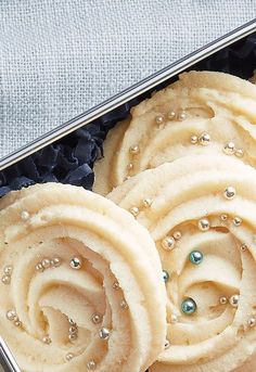 some kind of food that is in a metal container on a table with blue and white cloth