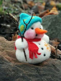 a small snowman sitting on top of a rock