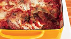 a yellow casserole dish filled with meat and cheese covered in marinara sauce