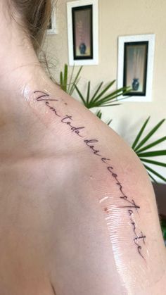 the back of a woman's shoulder with writing on it