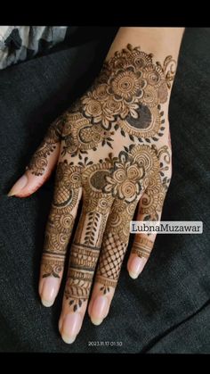 henna tattoo on the palm of a woman's hand, with intricate designs