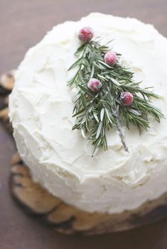 a cake with white frosting and green sprigs on top