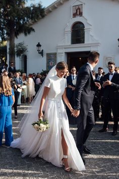 a bride and groom walking down the aisle at their wedding in front of a crowd