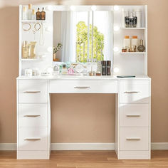 a white vanity with lights on it in front of a window