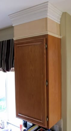 a kitchen with wooden cabinets and white trim on the top part of the cupboards