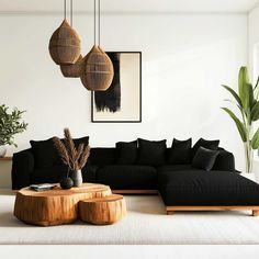 a living room with black couches and wooden tables in front of the wall is decorated with potted plants