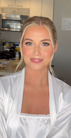 a woman wearing a white robe in a kitchen