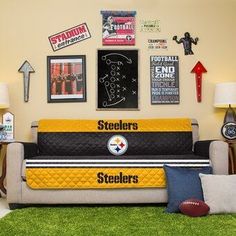 a football themed living room with couches and posters on the wall above it,