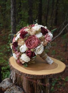 a bridal bouquet sitting on top of a tree stump