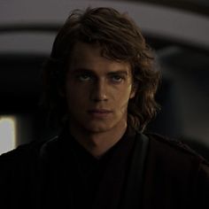 a young man with long hair and blue eyes stares at the camera while wearing a star wars uniform