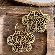 Adorn yourself with the celestial elegance of our Handcrafted Flower of Life Brass Hoop Lightweight Earrings - a perfect blend of sacred geometry and artisanal craftsmanship. Meticulously designed, these brass earrings feature the intricate Flower of Life pattern in a lightweight hoop, adding a touch of divine beauty to your everyday style. 🌸🌀 Key Features: - Handcrafted with precision, creating a pair of lightweight artisanal brass hoop earrings with Flower of Life design. - High-quality brass construction ensures enduring shine and durability. - Flower of Life pattern, symbolizing universal harmony and interconnectedness. - Lightweight and comfortable, perfect for daily wear with a touch of sacred elegance. Material: High quality brass  Width: 2 inches   Length: 2 inches. 🌟 Product De Bohemian Bronze Earrings With Intricate Design, Bohemian Bronze Earrings As Gift, Bohemian Bronze Earrings For Gift, Bohemian Brass Earrings With Intricate Design, Bohemian Bronze Plug Earrings, Bohemian Gold Plug Earrings For Festivals, Bohemian Metal Plug Earrings For Gift, Bohemian Flower Shaped Jewelry As A Gift, Bohemian Round Brass Plug Earrings