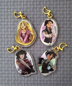 four disney princesses are hanging from key chains