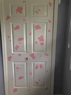 a white door with pink spots painted on the front and side doors, in a bathroom