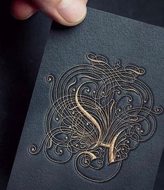 a person holding up a card with intricate designs on it