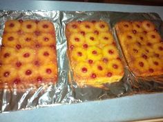 three pieces of food sitting on top of aluminum foil covered in pineapple toppings