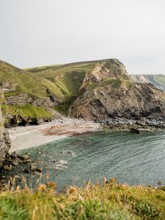 the water is crystal blue and clear with green hills in the backgrouds