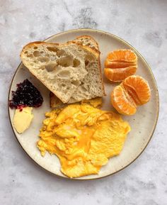 an omelet with toast, oranges and jam on a plate